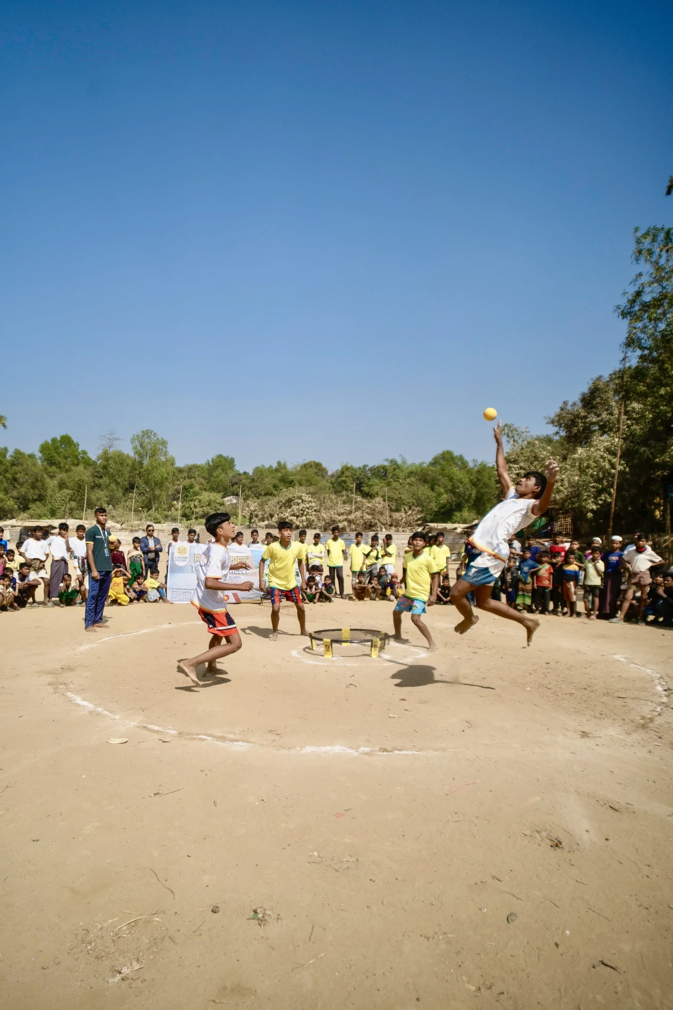 A roundnet tournament in the camp: players mid-air, a crowd watching